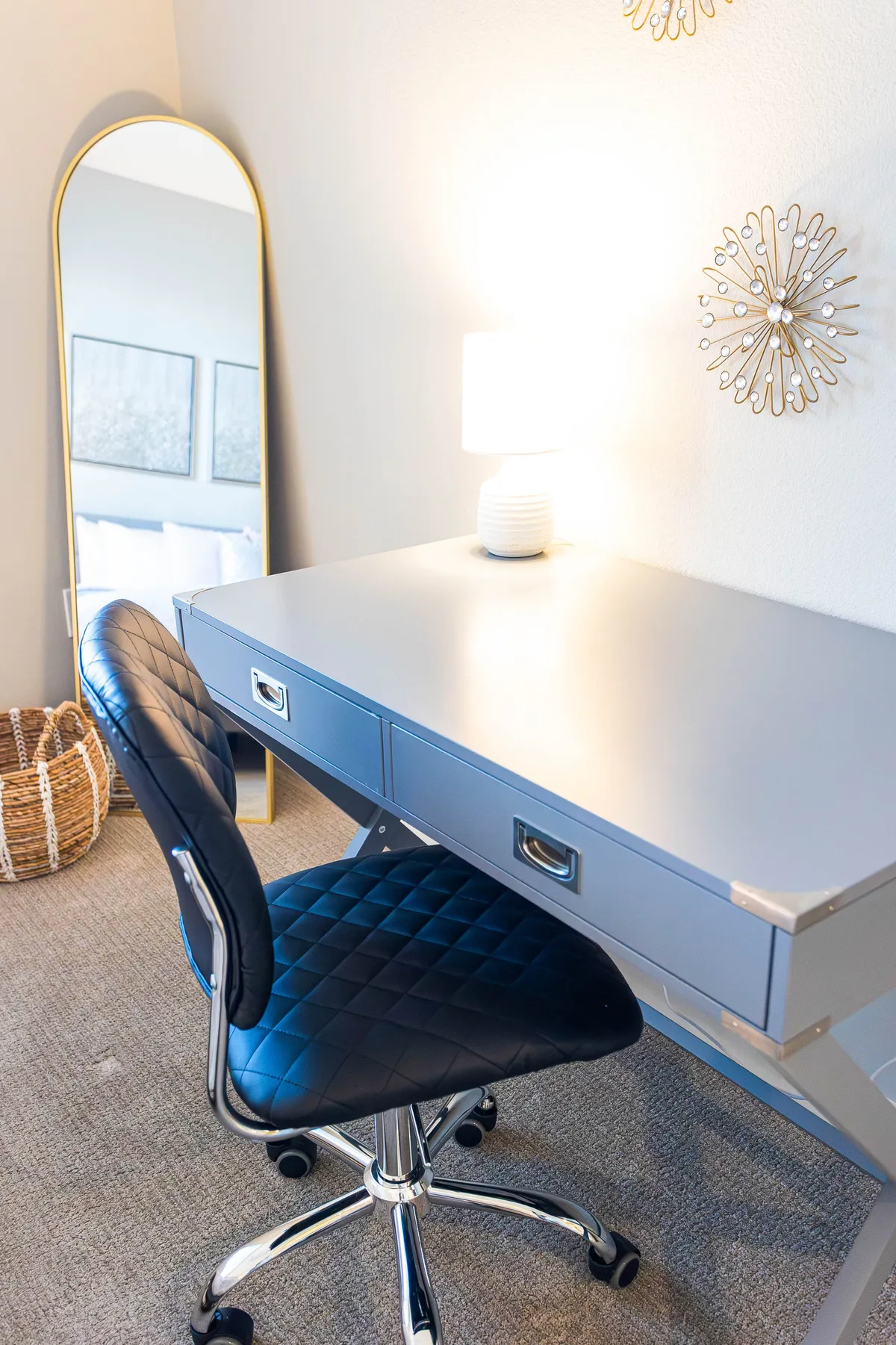 A dedicated office nook featuring a desk, chair, lamp, mirror, and wall decor. The mood is contemporary and cozy, visually highlighting an inspiring spot for working, studying, or reflecting—perfect for digital nomads or remote professionals.